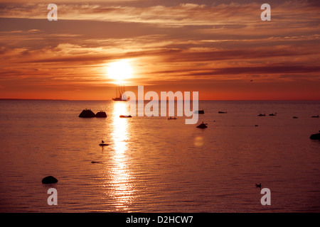 Tramonto sul mare sul fuoco con la nave a vela frigate silhouette Foto Stock