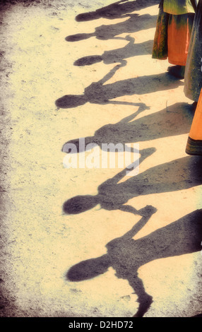 Ombra del villaggio indiano di bambini in una linea tenendo le mani per giocare. Andhra Pradesh, India Foto Stock