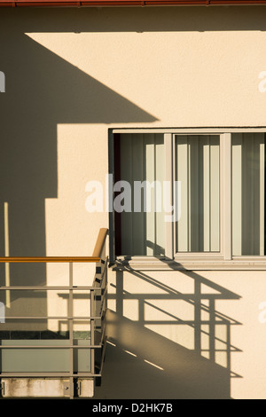 La luce del sole ed ombra dal balcone sulla facciata della casa Foto Stock