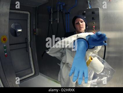 Virologist Lisa Oestereich detiene abbigliamento protettivo come essa si erge nel bloccare di nuovo la sicurezza biologica di livello 4 laboratorio del Bernhard Nocht Istituto di medicina tropicale (BNI) ad Amburgo, Germania, 25 gennaio 2013. Il nuovo labroratory contribuirà all'istituto di ricerche sulle malattie tropicali, comprese malattie pericolose come la febbre di Lassa, virus di Marburg, febbre di Ebola e la leishmaniosi. Foto: CHRISTIAN CHARISIUS Foto Stock