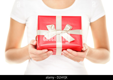 Primo piano delle mani femminili che mostra e regali con rosso carta da imballo e nastro bianco isolato su sfondo bianco Foto Stock