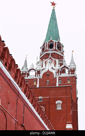 Neve a Mosca - rosso parete del Cremlino e Torre Troitskaya in inverno nevicava giorno Foto Stock