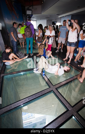 Le persone in piedi sul pavimento di vetro della CN Tower è un deck di visualizzazione a Toronto in Canada Foto Stock