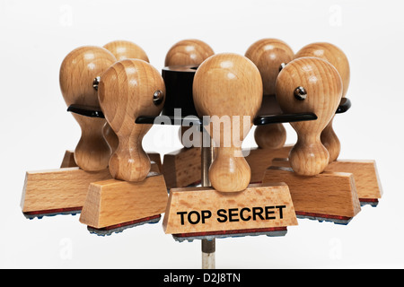 Molti francobolli appesa in un timbro rack. Un timbro con la scritta top secret si blocca nella parte anteriore, sfondo bianco. Foto Stock