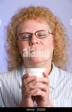Studio shot di donna di mezza età con ricci capelli rossi Foto Stock