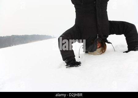 Berlino, Germania, donna facendo un headstand nella neve Foto Stock