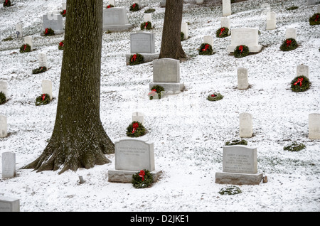 Arlington National Cemetery Headstones Wreath Snow Arlington Virginia // Headstones at Arlington National Cemetery in the Snow. I volontari hanno aggiunto una corona festiva ad ogni tomba. Arlington, Virginia, Stati Uniti. Foto Stock