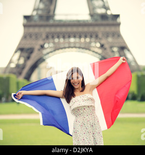 Donna che mantiene bandiera francese dalla Torre Eiffel a Parigi. Turisti in viaggio in Europa. Foto Stock