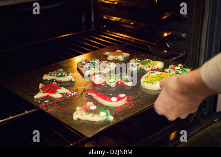 Una bambina decora biscotti di Natale prima della loro cottura Foto Stock