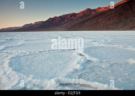 Salina poligoni sotto la montagna nera a Badwater durante il tramonto, il Parco Nazionale della Valle della Morte, California. Foto Stock