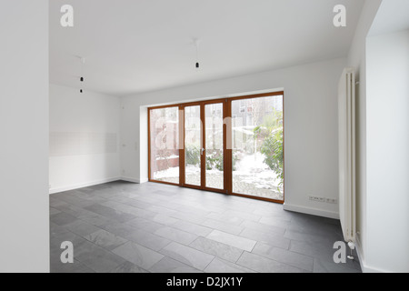 Berlino, Germania, camere con finestre in legno e pavimento in pietra nella nuova costruzione di una casa di riga Foto Stock
