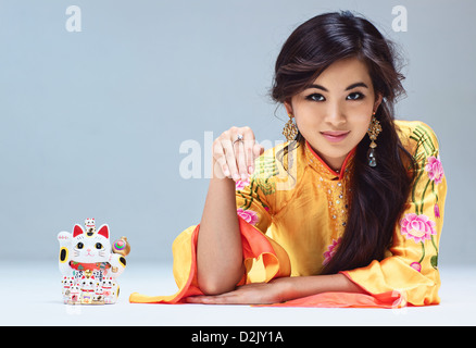 Giovane donna giapponese con Maneki Neko cat. Foto Stock