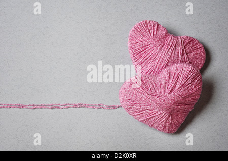 Cuore rosa forma fatti di lana su sfondo grigio Foto Stock