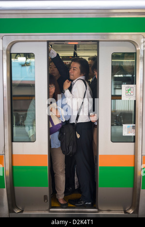 Lavoratori affollata durante le ore di punta su un treno a Tokyo Giappone Foto Stock