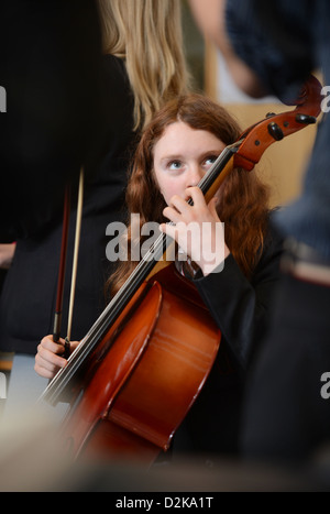 Una ragazza con un violoncello durante un'orchestra pratica presso Pâté Grammar School di Cheltenham, Gloucestershire REGNO UNITO Foto Stock