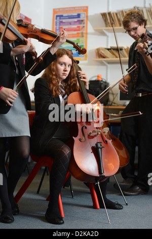 Una ragazza con un violoncello durante un'orchestra pratica presso Pâté Grammar School di Cheltenham, Gloucestershire REGNO UNITO Foto Stock