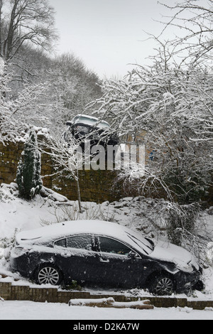 Una Range Rover (sopra) che ha colpito un fermo Vauxhall dopo lo scorrimento in condizioni nevose forzandolo in giardini sotto su una collina Foto Stock