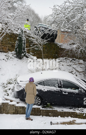 Una Range Rover (sopra) che ha colpito un fermo Vauxhall dopo lo scorrimento in condizioni nevose forzandolo in giardini sotto su una collina Foto Stock