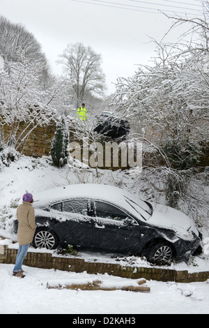 Una Range Rover (sopra) che ha colpito un fermo Vauxhall dopo lo scorrimento in condizioni nevose forzandolo in giardini sotto su una collina Foto Stock