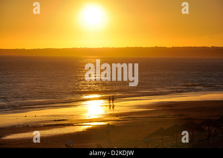 Giovane passeggiate sulla spiaggia al tramonto in Gale, distretto di Faro, regione di Algarve, PORTOGALLO Foto Stock