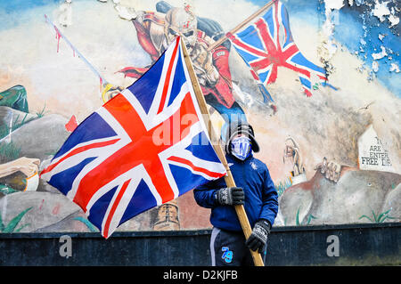 Il 27 gennaio 2013, Londonderry, Irlanda del Nord. Un giovane ragazzo protestante detiene una bandiera dell'Unione di fronte a una parete murale, copiati da Iron Maiden album 'il soldato'. Foto Stock