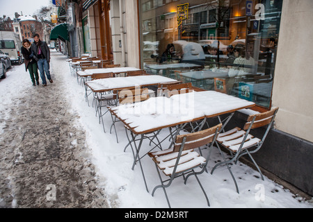 Tabelle vuote con neve a bar a Bruxelles, in Belgio Foto Stock