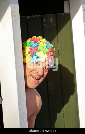 Uomo che indossa cuffia coetanei fuori da spogliatoi presso la piscina all'aperto a Tooting Bec Lido South London REGNO UNITO Foto Stock