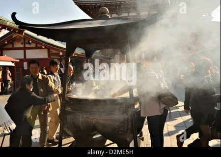 Visiors e turisti affollano il bruciatore di incenso o koro al tempio di Sensoji, Asakusa, Tokyo Foto Stock