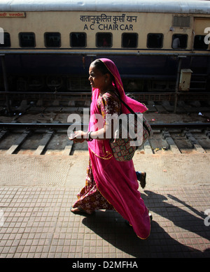 Vista generale di una donna che cammina lungo la piattaforma di Ajmer stazione ferroviaria nel Rajasthan, India Foto Stock