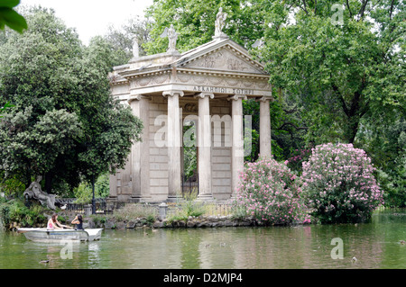 Roma. L'Italia. Persone in barche barca a remi intorno al tempio ionico di Esculapio. I giardini di Villa Borghese lago (Giardino dei Lago) Foto Stock