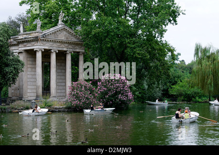 Roma. L'Italia. Persone in barche barca a remi intorno al tempio ionico di Esculapio. I giardini di Villa Borghese lago (Giardino dei Lago) Foto Stock