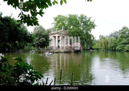 Roma. L'Italia. Persone in barche barca a remi intorno al tempio ionico di Esculapio. I giardini di Villa Borghese lago (Giardino dei Lago) Foto Stock