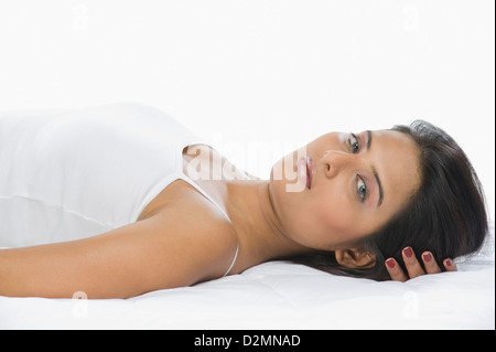 Ritratto di una donna sdraiata sul letto Foto Stock