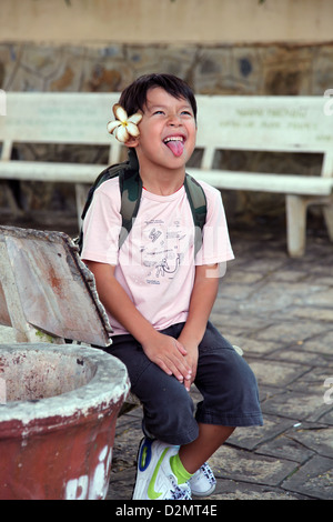 Si tratta di una foto di un adorabile ragazzo asiatico che ha un fiore nei capelli. Egli sta facendo una faccia impertinente ed è felice di farlo. Foto Stock