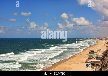 Vista aerea sulla bellissima spiaggia lungo il mare Mediterraneo litorale con onde bianco sotto il cielo blu con nuvole in Ashqelon, Israele Foto Stock