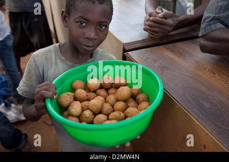 NAMPULA, Mozambico, Maggio 2010 : MERCATO DI DOMENICA - un ragazzo vende dolce fritto pane. Foto di Mike Goldwater Foto Stock