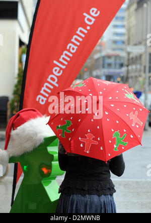 Una donna porta un ombrello Ampelmann a Gendarmenmarkt a Berlino, Germania, 28 novembre 2012. Il Ampelmännchen (poco traffico luce l'uomo) della Germania orientale è stato il primo semaforo pedonale simbolo e divenne un icona del 'Ostalgie', un tipo speciale di nostalgia dei tedeschi orientali per la vita di tutti i giorni nella ex RDT. Foto: Jens Kalaene Foto Stock