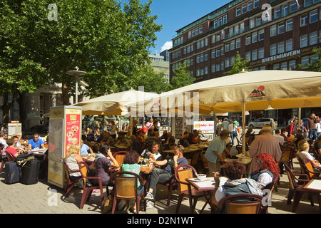 La gente seduta al fresco presso la caffetteria con ombrelloni sulla Moenckebergstrasse nel cuore dello shopping del centro della città di Amburgo, Germania Foto Stock