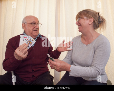 Uomo anziano giocare gioco di carte con la figlia Foto Stock