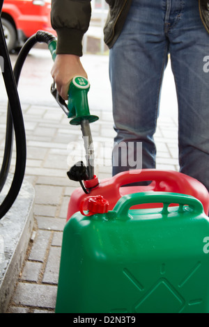 Uomo in jeans gas in una stazione di benzina in plastica barattolo 98E Foto Stock