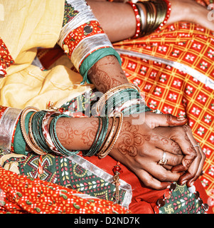 Le mani di una giovane donna indiana decorati con tradizionali schiave e mehndi. Foto Stock