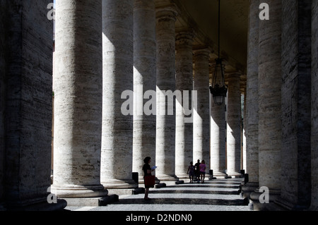 Vista di una persona a leggere un libro nel cuore di Gian Lorenzo Bernini colonnato monumentale al Saint Peters Foto Stock