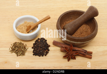 Ingredienti per il cinese cinque spezie con un ramekin e pestello e mortaio su una tavola di legno Foto Stock