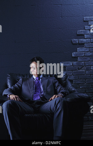 Imprenditore seduto su un divano Foto Stock