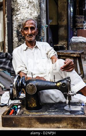 Ritratto di vecchio sarto con vintage macchina da cucire a Lahore, in Pakistan. Foto Stock