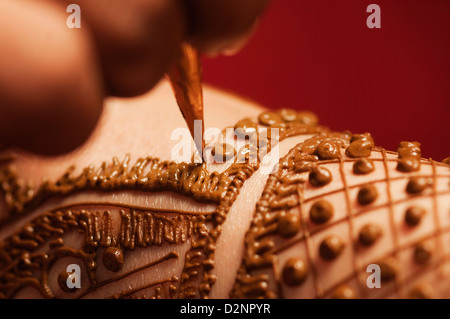 Donna di mano applicando henna sulla sposa la mano Foto Stock