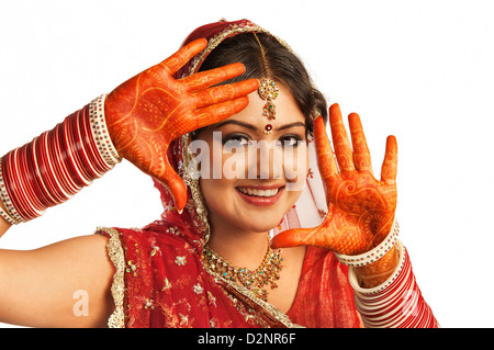 Ritratto di una sposa che mostra henna decorate palms e sorridente Foto Stock