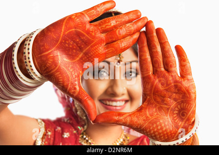 Ritratto di una sposa che mostra henna decorate palms e sorridente Foto Stock