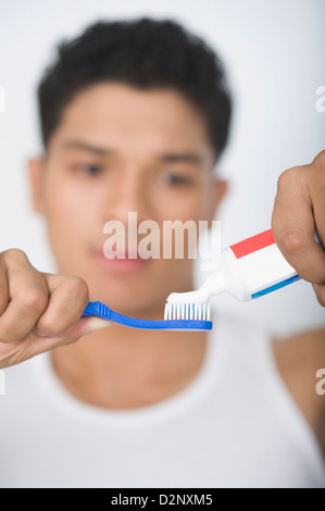 Uomo di applicare il dentifricio sullo spazzolino Foto Stock