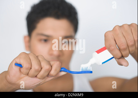 Uomo di applicare il dentifricio sullo spazzolino Foto Stock